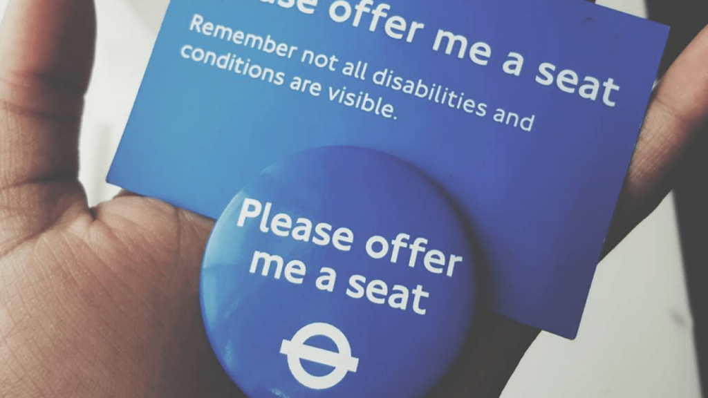 A badge and a card from Transport London stating: "please offer me a seat"